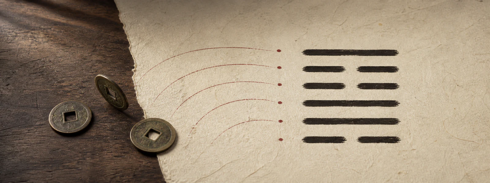Three antique coins on rice paper beside a six-line I Ching hexagram